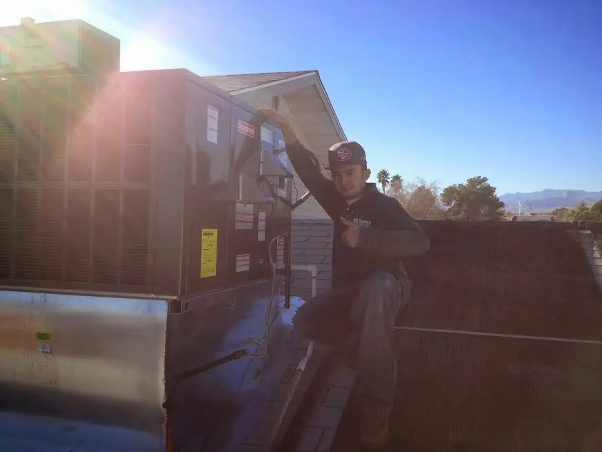 HVAC technician performing AC Tune-Up on a rooftop unit in Barnesville